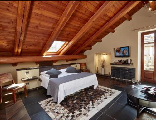 Un dormitorio con una cama grande en una habitación con techos de madera. en Casa Svizzera Agriturismo, en Barolo