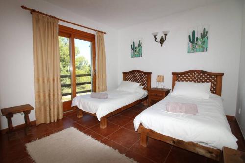 een slaapkamer met 2 bedden en een raam bij Villa Olga - San Jose in San Jose de sa Talaia