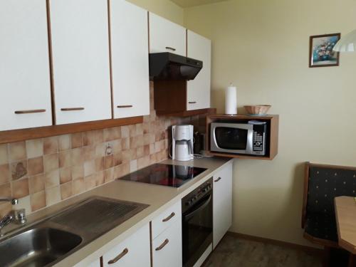 eine kleine Küche mit einer Spüle und einer Mikrowelle in der Unterkunft Haus Reinstadler in Imst