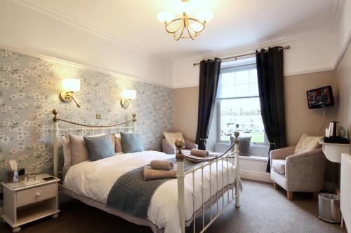 um quarto com uma cama, uma cadeira e uma janela em Ivy Cottage Bed & Breakfast em Reeth