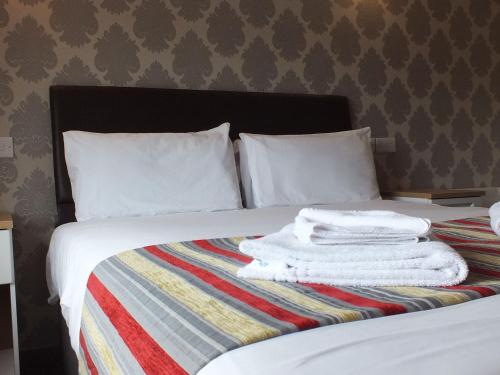 a bed with white towels sitting on top of it at The Fazeley Inn in Fazeley