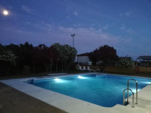 an empty swimming pool at night at Hotel La Barca in Lepe