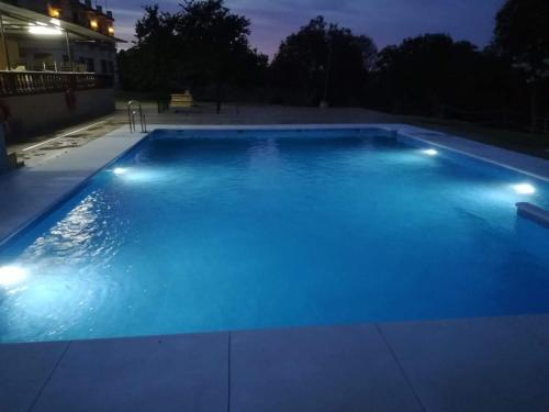 a large swimming pool with lights on it at night at Hotel La Barca in Lepe
