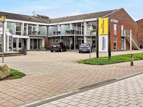 a parking lot with cars parked in front of a building at 8 person holiday home in Ringkøbing-By Traum in Ringkøbing
