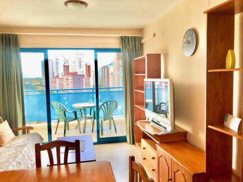 a room with a bed and a view of a balcony at BENIDORM CENTER KENNEDY APARTMENT in Benidorm