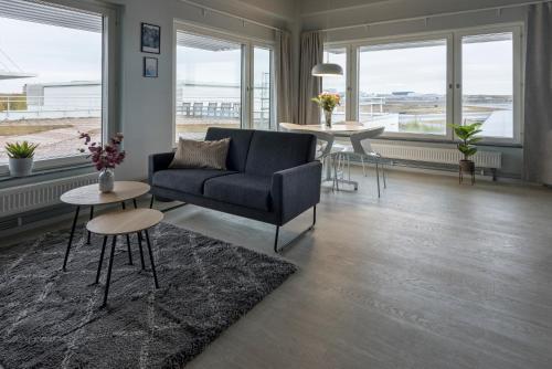 a living room with a couch and tables and windows at Forenom Hotel Arlanda in Arlanda