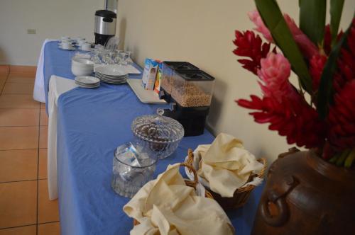 a table with a blue table cloth and a vase of flowers at Hotel Verona in San Pedro Sula
