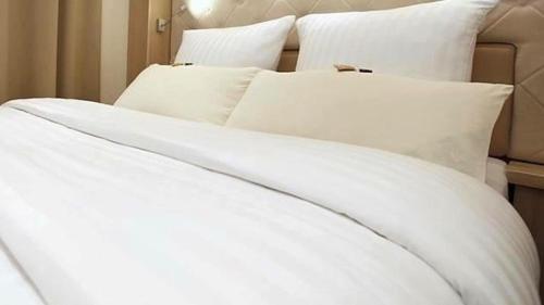 a white bed with white sheets and pillows at Hotel Villa Will in Hannover