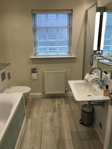 a bathroom with two sinks and a tub and a toilet at Foyles of Glasbury in Glasbury