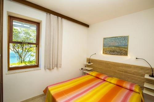 una camera con letto e finestra di Un Nido sul Mare - Goelba a Portoferraio