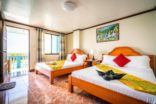 Blue Corals Beach Resort في جزيرة مالاباسكوا: غرفة فندقية بسريرين ونافذة