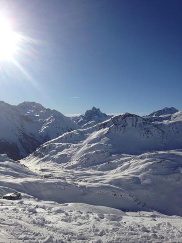 a snow covered mountain with the sun in the sky at Gasslihof in Sankt Anton am Arlberg