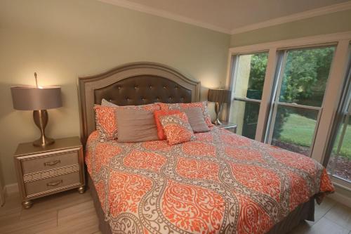 a bedroom with a bed with an orange and gray comforter at 1/1 bed&bath condos 5 min drive to Siesta in Sarasota