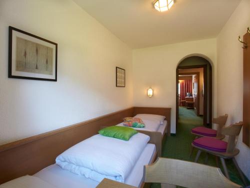 a room with three beds and a table and chairs at Landhaus Schwarz in Mieming
