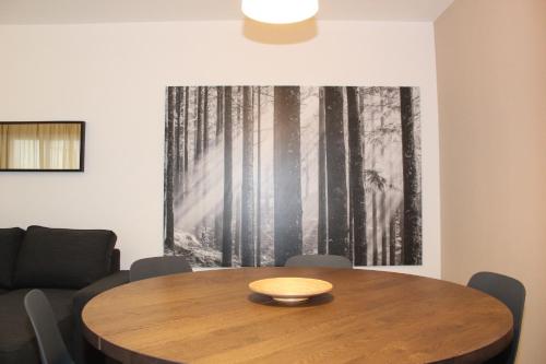 a dining room with a wooden table and a painting on the wall at Apartamento con Terraza a 5 min playa in Rincón de la Victoria