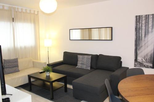 a living room with a couch and a table at Apartamento con Terraza a 5 min playa in Rincón de la Victoria