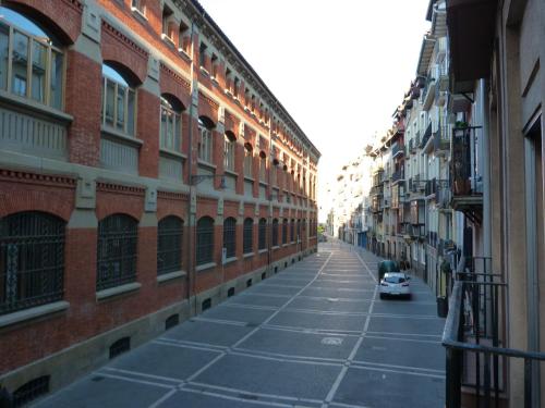 an empty street with buildings and a car on it at Apartamento Berria in Pamplona