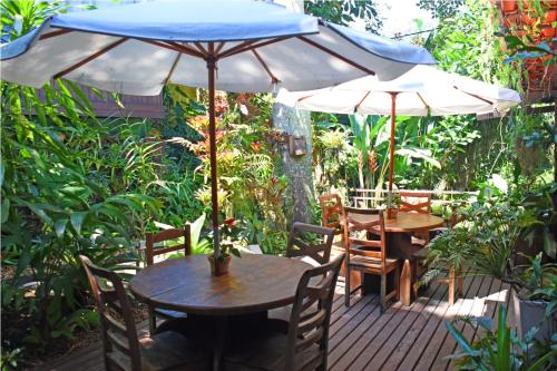 a wooden deck with a table and an umbrella at Pousada Riacho Dos Cambucas in Abraão