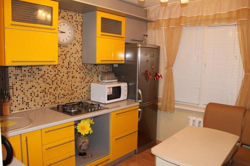 a kitchen with yellow cabinets and a microwave at Comfortable Apartments in Kryvyi Rih