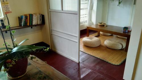 Habitación con mesa y 2 taburetes en el suelo en ZYIN Homestay, en Kaohsiung