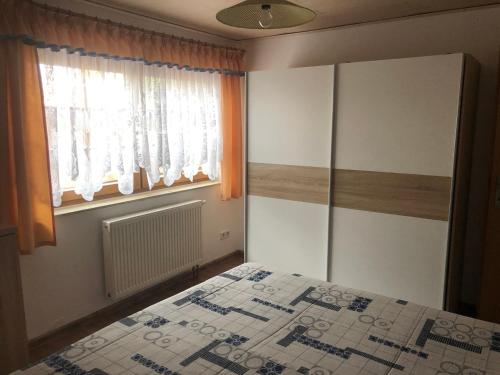 1 dormitorio con cama y ventana en Am Tor zur Sächsischen Schweiz en Lohmen