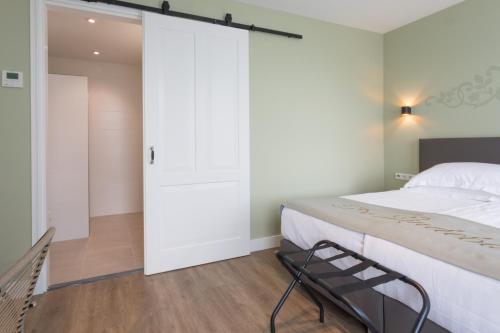 a bedroom with a bed and a sliding door at B&B - Brasserie De Lindeboom in Serooskerke
