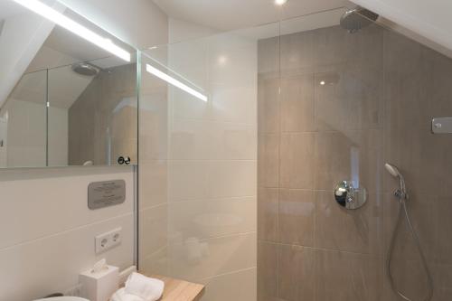 a bathroom with a shower with a glass door at B&B - Brasserie De Lindeboom in Serooskerke