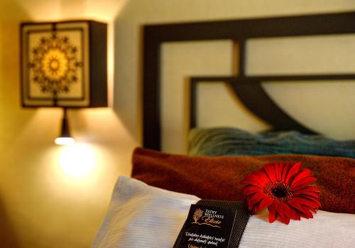 a red flower sitting on top of a bed at Hotel Grand Jasná in Demanovska Dolina