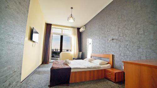a bedroom with a bed and a large window at Plaza Inn Batumi in Batumi