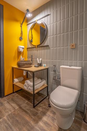 a bathroom with a white toilet and a mirror at Tbilisi Story Hotel in Tbilisi City