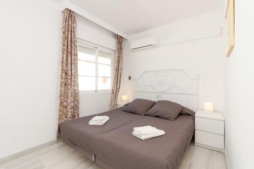 ネルハにあるBurriana Playa Carmona Nerjaのベッドルーム1室(ベッド1台、タオル2枚付)