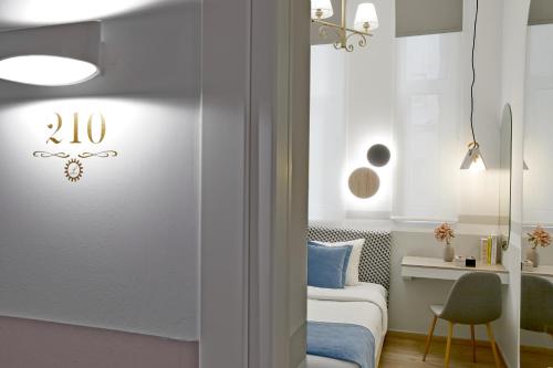 a small bedroom with a bed and a desk at Hotel Luxembourg in Thessaloniki