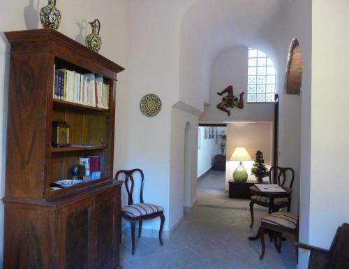 sala de estar con estantería y sillas en La Durlindana B&B, en Acireale