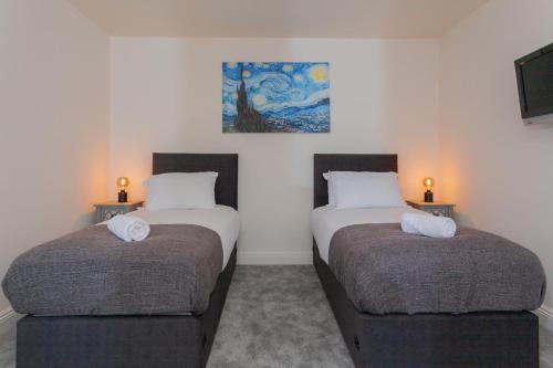 two twin beds in a room with two lamps at Escape Ordinary at Castle Hume in Enniskillen