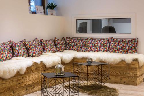 a living room with a wooden couch with pillows at Hotel KLE, BW Signature Collection in Kaysersberg