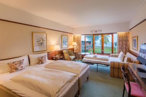 una camera d'albergo con due letti e un soggiorno di Hotel Hesselet a Nyborg