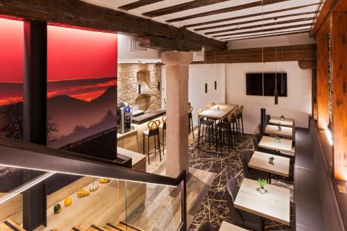 a dining room with a table and chairs and a large window at Hotel KLE, BW Signature Collection in Kaysersberg