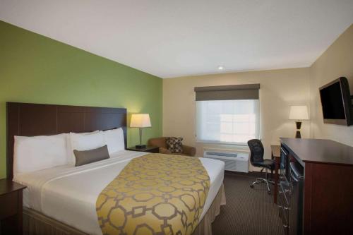 a hotel room with a bed and a desk at Baymont by Wyndham Jefferson City in Jefferson City