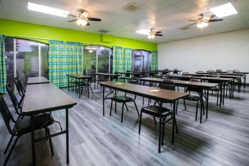 a dining room with tables and chairs and green walls at Super 8 by Wyndham Ft Stockton in Fort Stockton