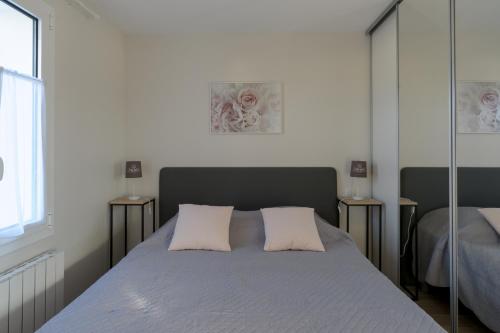 una camera con un letto con due cuscini sopra di Les Raisins du Bonheur a Puisseguin