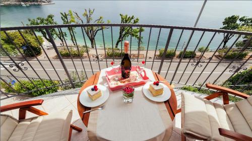 a table with two slices of cake and a bottle of wine at Apartment Villa Lidija in Lovran