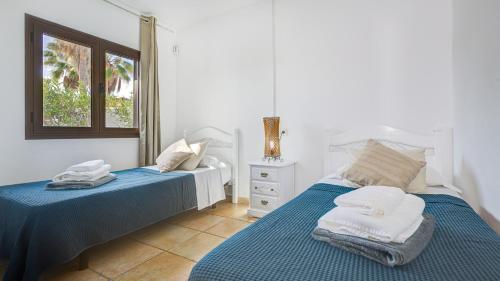 1 dormitorio con 2 camas y ventana en Villa Sávila, en Caleta de Fuste