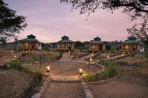 un conjunto de 4 villas por la noche con luces en Jawai Leopard Safari Lodge, en Bera