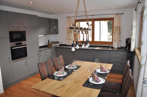 a kitchen with a wooden table and chairs in a kitchen at Seebach Chalets in Scheffau am Wilden Kaiser