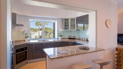 a kitchen with a counter and a large window at Sienna in Vale do Lobo