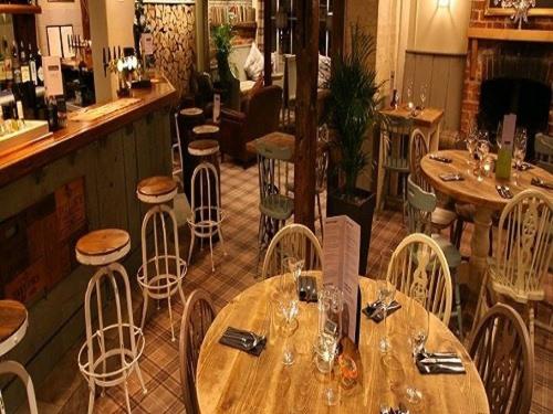 een restaurant met houten tafels en stoelen en een bar bij The Fox & Hounds in Swindon