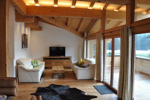 a living room with two couches and a tv at Seebach Chalets in Scheffau am Wilden Kaiser