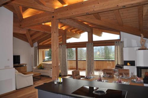 een keuken en een woonkamer met een groot houten plafond bij Seebach Chalets in Scheffau am Wilden Kaiser
