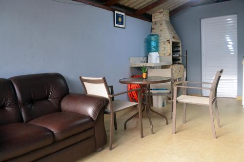 een woonkamer met een bank en een tafel en stoelen bij CASA PRAIA A 600m DO MAR in Balneário Camboriú