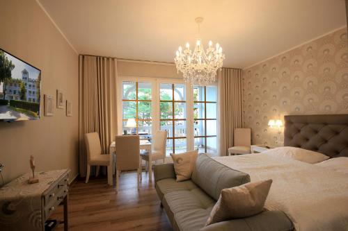ビンツにあるAparthotel Ostsee by Rujanaのベッドルーム1室(ベッド1台、ソファ、テーブル付)